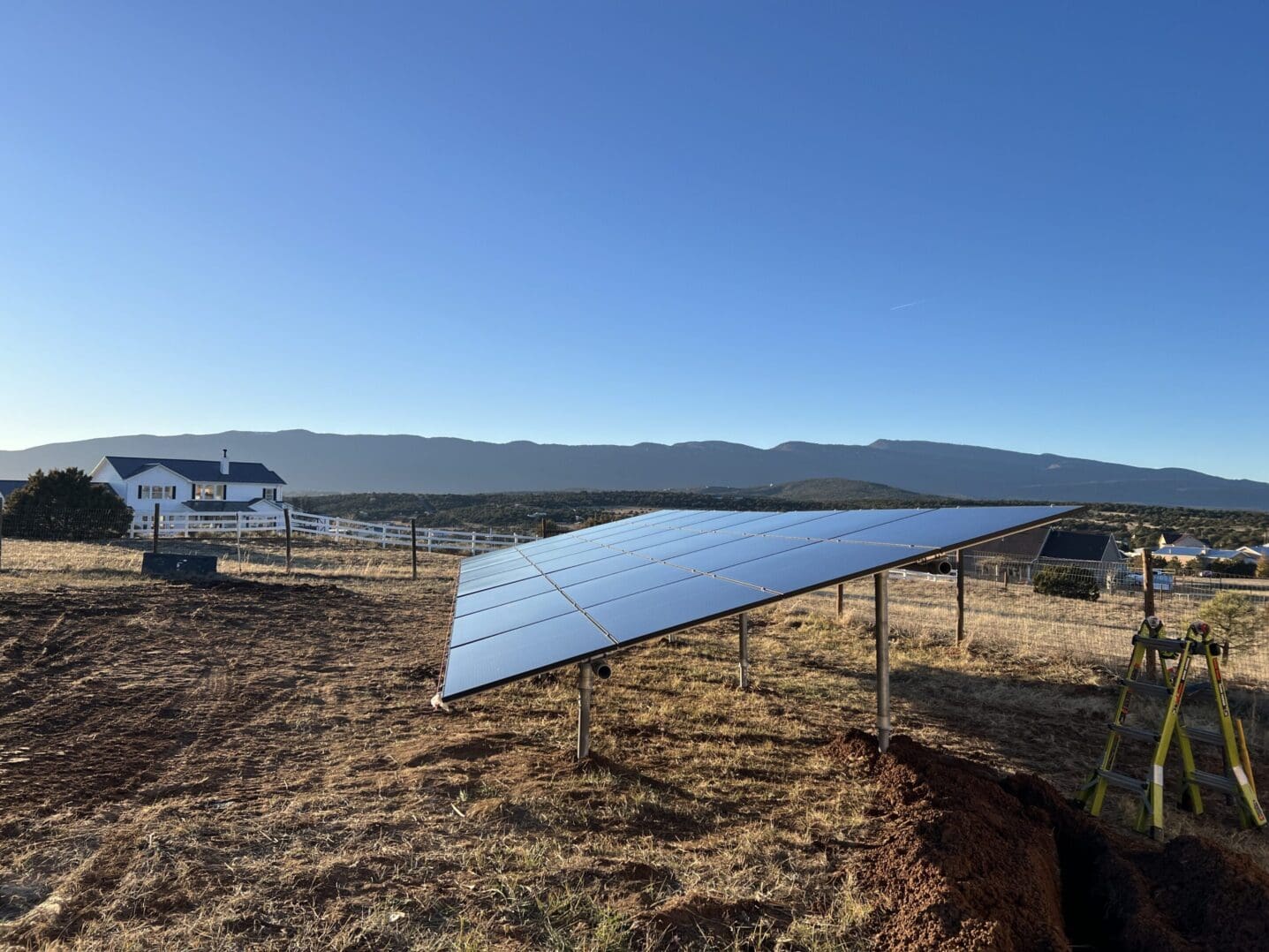 A solar panel sitting in the middle of an open field.